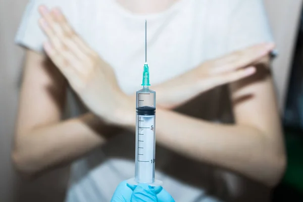 Stop vaccinaties. Een injectiespuit in de hand van de arts en een patiënt zegt nee. — Stockfoto