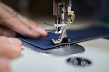 Bir adam dikiş makinesinde deriden dikiş diker. Eller ve dikiş.. 