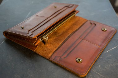 U dönüşü kahverengi el yapımı deri cüzdan. Koyu bir arka planda kahverengi deri çanta.