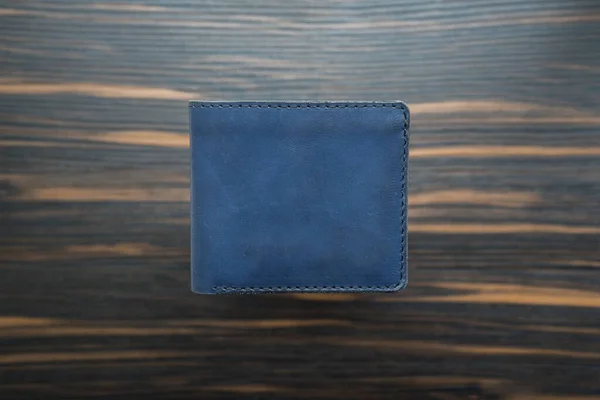 蓝色手工皮夹,深色木制背景.顶部视图 — 图库照片