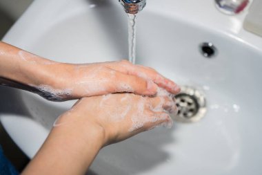 Ellerini sabunla yıka. Coronavirüsü önlemek için ellerini yıkıyor..