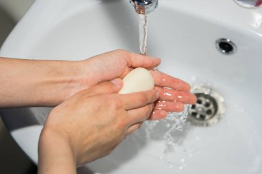 Ellerini sabunla yıka. Coronavirüsü önlemek için ellerini yıkıyor..