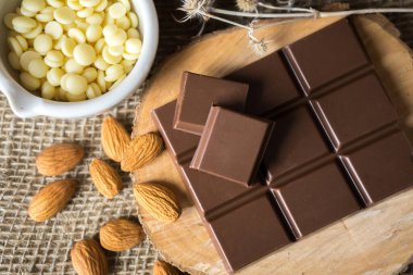 Kakao tereyağlı çikolata ve tahtada badem.