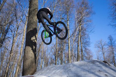 Adam kışın bisiklet numarası yapıyor. Adam Moto 'ya bisiklette kırbaç numarasını gösteriyor.. 