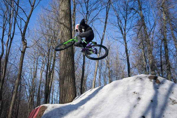 Bir bisikletçi kışın sıçrama tahtasında 360 numara yapar. Sporcu bir numara gösteriyor. — Stok fotoğraf