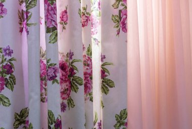 Çiçek desenli ve oturma odası penceresindeki tül perdeler.