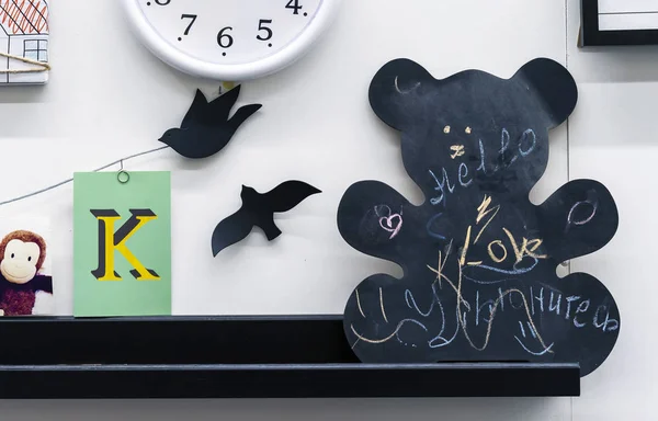 纸板的粉笔在熊的形式。黑板上的题字是英文的 "爱"、"你好" 和俄语的 "微笑". — 图库照片