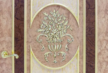 Giriş kapısı ile yaldızlı trim ve çiçek tasarımları.