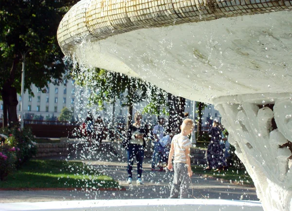 Мальчик фотографируется на фоне фонтана в парке . — стоковое фото