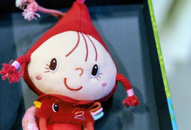 Pigtails içinde kırmızı bere ile yumuşak oyuncak bebek.