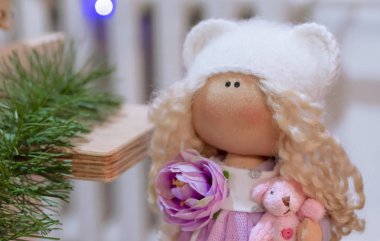 Yumuşak oyuncak bebek beyaz tüylü şapkalı.