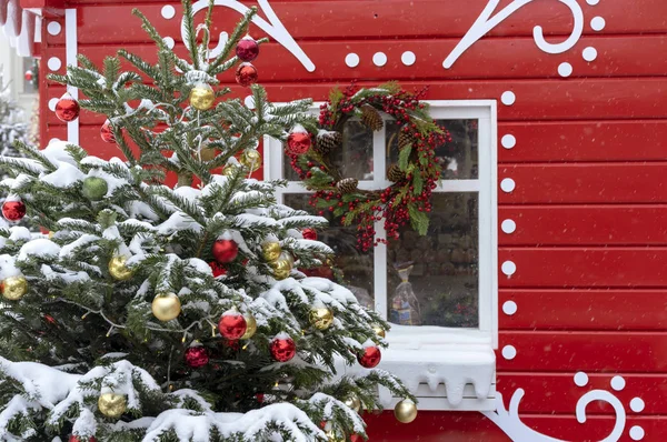 Süslenen bir kırmızı masal ev arka plan üzerinde Noel ağacı.