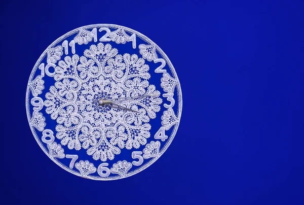 Relógio de renda branco em um fundo azul . — Fotografia de Stock