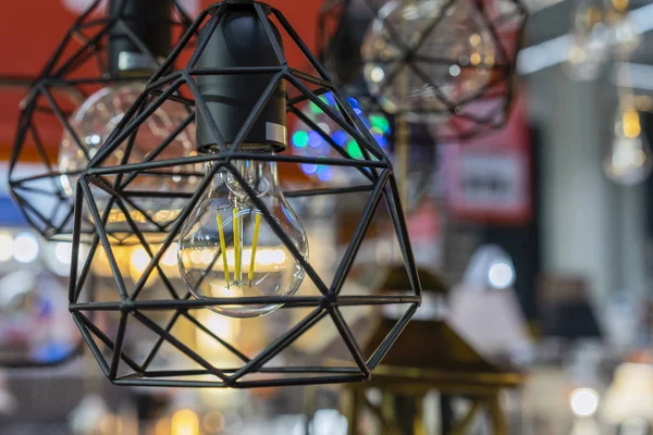 Lampe de style du loft dans un intérieur de boutique. Une lampe élégante dans un cadre métallique . — Photo