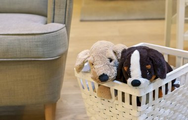 Beyaz hasır sepette iki peluş köpek yavrusu. Yumuşak oyuncak köpek yavrusu.