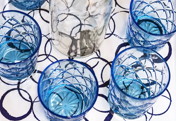 Gobelets en verre bleu avec carafe blanche. Ustensiles de cuisine en verre bleu . — Photo