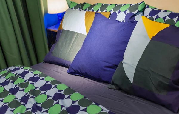 Travesseiros com fronhas brilhantes no interior do quarto . — Fotografia de Stock