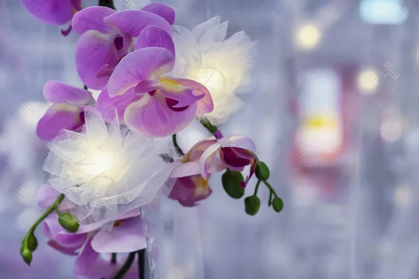Garland z gałęzią orchidei. Wystrój wnętrz. Sztuczny kwiat orchidei. — Zdjęcie stockowe