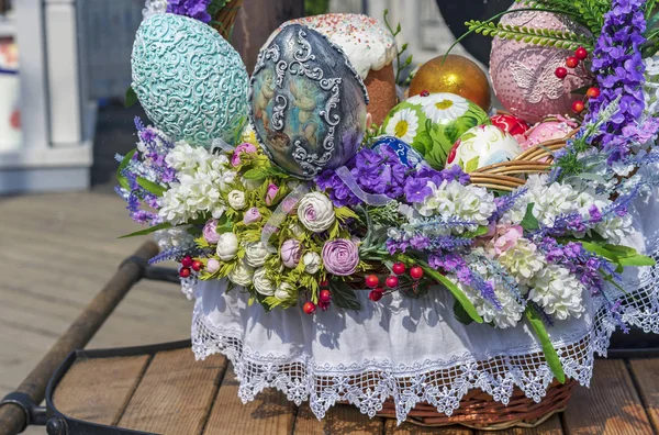 Цветные пасхальные яйца и пасхальные торты в плетеной корзине . — стоковое фото