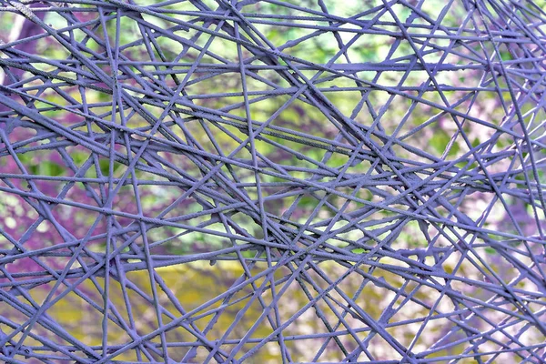 Texture of metal wire against the backdrop of nature. Background of purple wire. — Stock Photo, Image