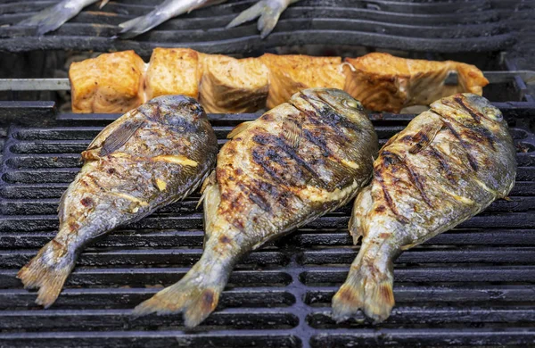 Izgarada ızgara Dorada balığı ve Somon dilimleri.