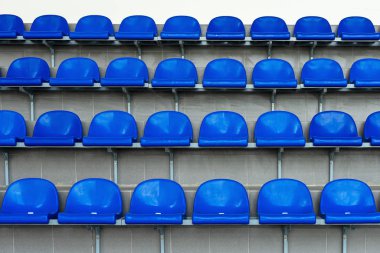 Stadyumda mavi plastik koltuklar. Tribün taraftarları. Stadyumdaki seyirciler için koltuklar.
