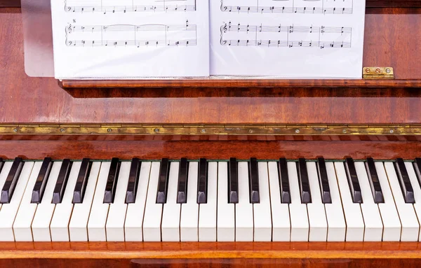 Tastatur auf einem braunen Klavier. Schwarz-weiße Tasten auf der Tastatur des alten Klaviers. — Stockfoto