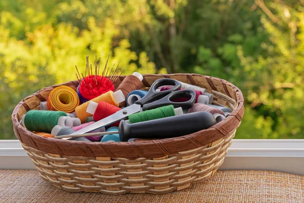 Fils à coudre multicolores dans un panier en osier. Bobines de fil pour la couture. Le concept des accessoires de couture . — Photo