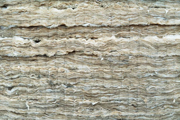 Mineral wool is used as a thermal insulation material in the construction of a house. Glass wool background.