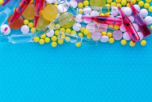 Ampullen für Injektionen, Pillen und Vitamine auf blauem Hintergrund. medizinisches Konzept. — Stockfoto
