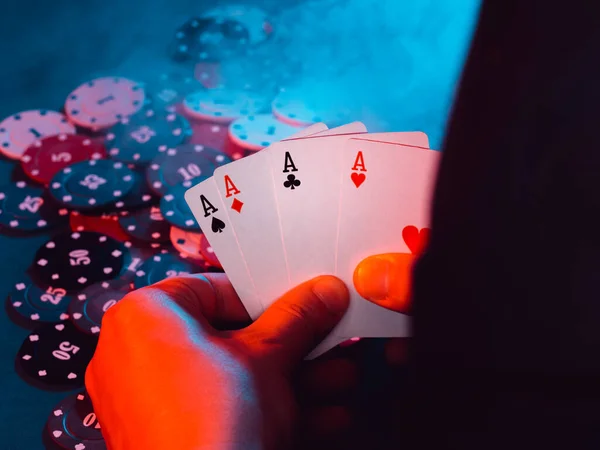 Poker. las manos de los hombres sostienen las cartas de ases contra el fondo de jugar fichas. la foto muestra humo —  Fotos de Stock