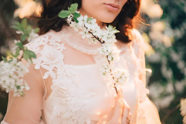 Hermosa joven en un vestido ligero en el fondo de un jardín floreciente. de cerca — Foto de Stock