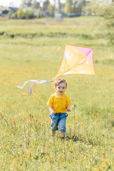 Feliz chico corre al aire libre con una cometa —  Fotos de Stock