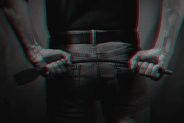 Seksi bir adam arkasında kırmızı bir arka planda kırbaç tutuyor. 3 boyutlu sanal gerçeklik efektiyle siyah ve beyaz