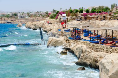 Sharm El Sheikh, Mısır - 8 Mayıs 2018: Bilinmeyen insanlar otel Siva Sharm (ex. Savita Resort) kumsalda dinlenmek 5 * Sharks Bay. Kırmızı bayrağı sahilde uyarı