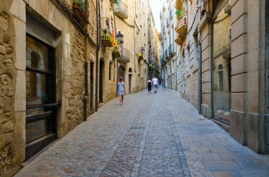 Girona, İspanya - 11 Eylül 2018: Girona, İspanya'nın tarihi merkezindeki dar cadde boyunca bilinmeyen insanlar yürümek