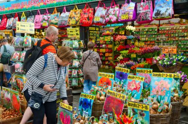 AMSTERDAM, NETHERLANDS - SEPTEMBER 6, 2018: Unidentified people are at famous flower market in Amsterdam, North Holland, Netherlands clipart