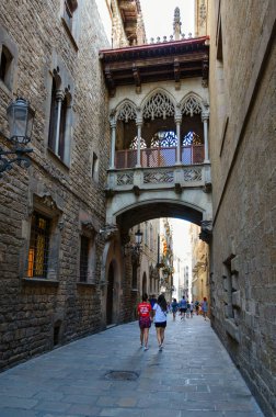 Barcelona, İspanya - 13 Eylül 2018: Aşağı sokak Carrer del Bisbe altında ünlü Bridge of Sighs (Pont dels Sospirs) Gothic Quarter, Barselona, İspanya, tanımlanamayan turist yürüyüş