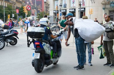 Barcelona, İspanya - 13 Eylül 2018: Hediyelik eşya Plaza Catalunya, Barselona, İspanya, yasadışı ticaret. Bilinmeyen polis memuru uyarı tüccar yapar.