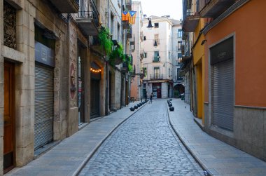 Girona, İspanya - 11 Eylül 2018: Tanımlanamayan turist Girona, İspanya'nın tarihi merkezindeki dar sokak boyunca yürüyün