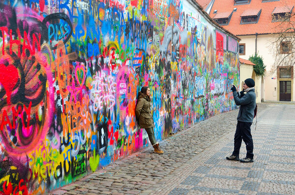 PRAGUE, CZECH REPUBLIC - JANUARY 22, 2019: Unidentified tourists are photographed at famous wall of John Lennon in Prague, Czech Republic