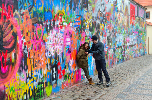 PRAGUE, CZECH REPUBLIC - JANUARY 22, 2019: Unidentified young people are photographed at famous wall of John Lennon in Prague, Czech Republic