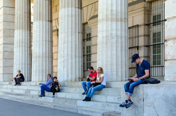 People rest on steps near columns of Portal of Heroes (External fortress gates, Burgtor), Vienna, Austria — Stock Photo, Image