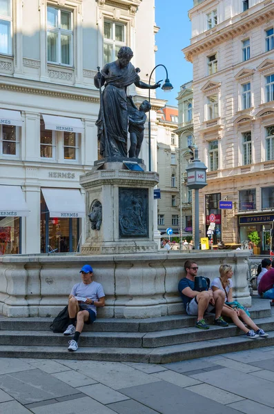 Люди отдыхают возле фонтана Иосифа, или Фонтана Иосифа Обрученного, на улице Грабен, Вена, Австрия — стоковое фото
