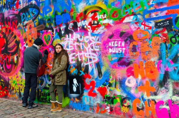 Young people leave inscription on famous wall of John Lennon in Prague, Czech Republic — Stock Photo, Image