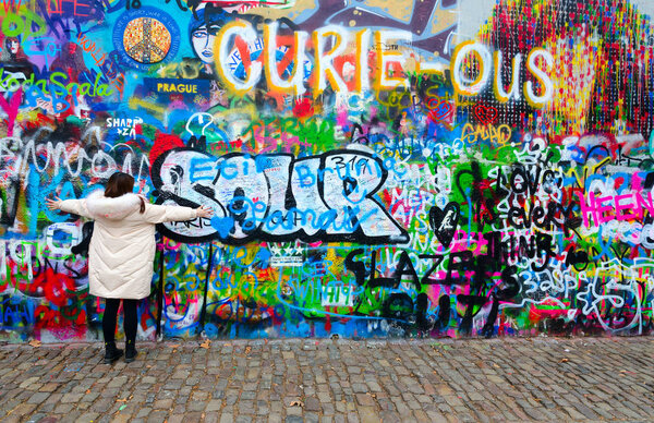 Tourist is located at famous wall of John Lennon in Prague, Czech Republic