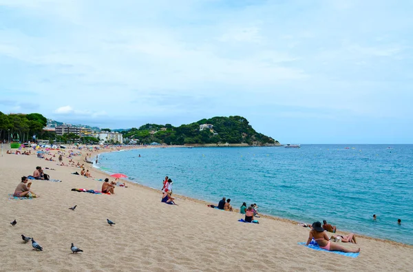 People relax on popular Fenals beach in resort town of Lloret de Mar, Costa Brava, Catalonia, Spain — Stock Photo, Image