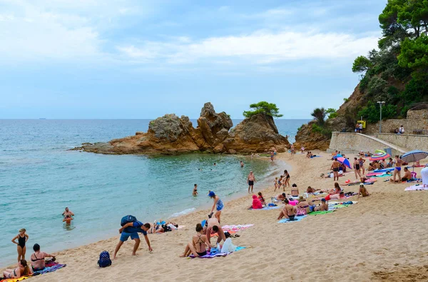 Menschen entspannen sich am beliebten Fenals Strand in Ferienort lloret de mar, costa brava, Katalonien, Spanien — Stockfoto