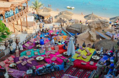 People are relaxing in popular Farsha cafe outdoors on shore of Red Sea in Hadaba district, Sharm El Sheikh, Egypt clipart