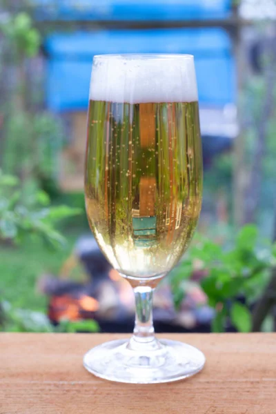 暖かい夜に冷たいビールとガラス グリルで焼ける火を背景にしたビール — ストック写真